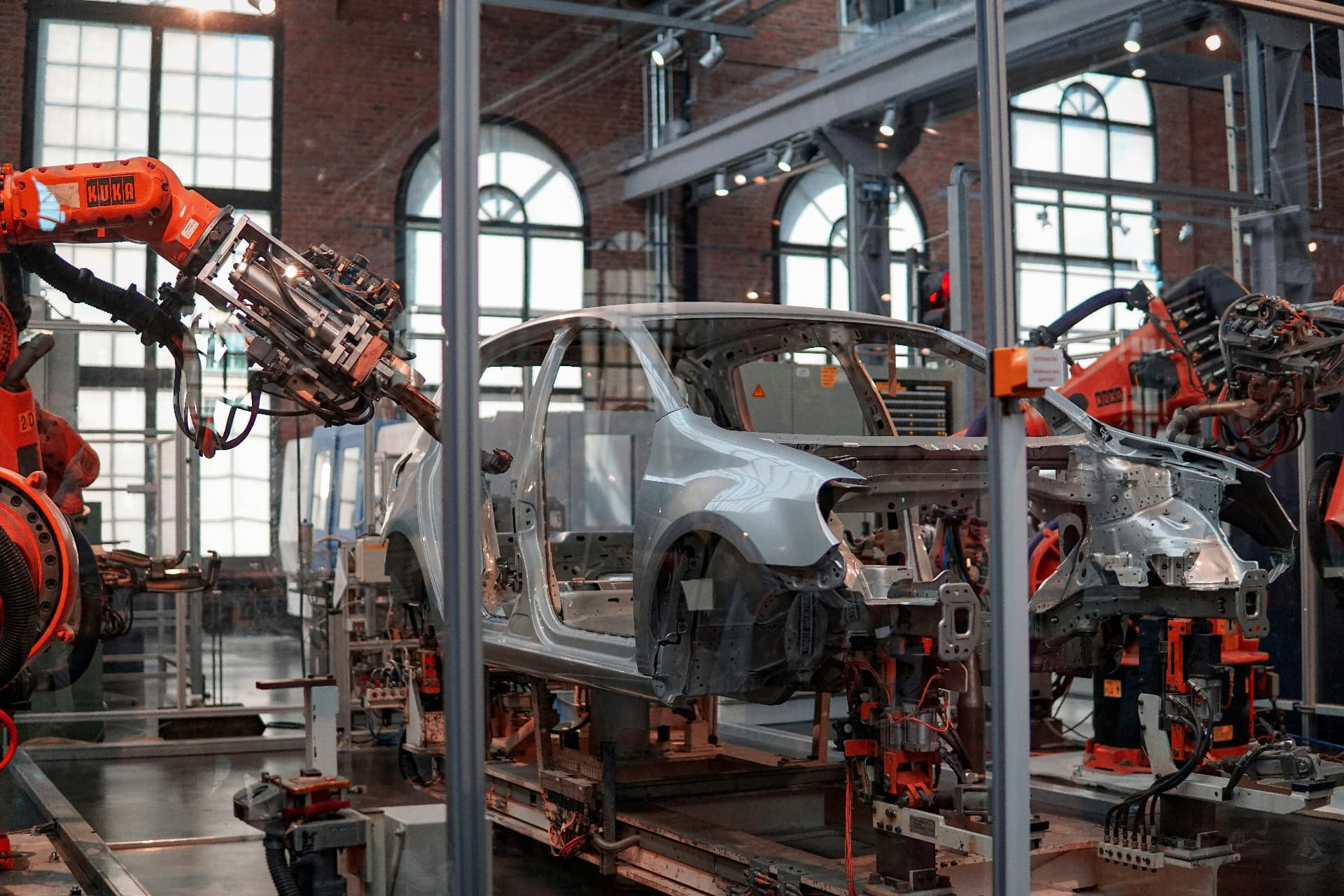 Robotic arms working on a car body in an assembly hall