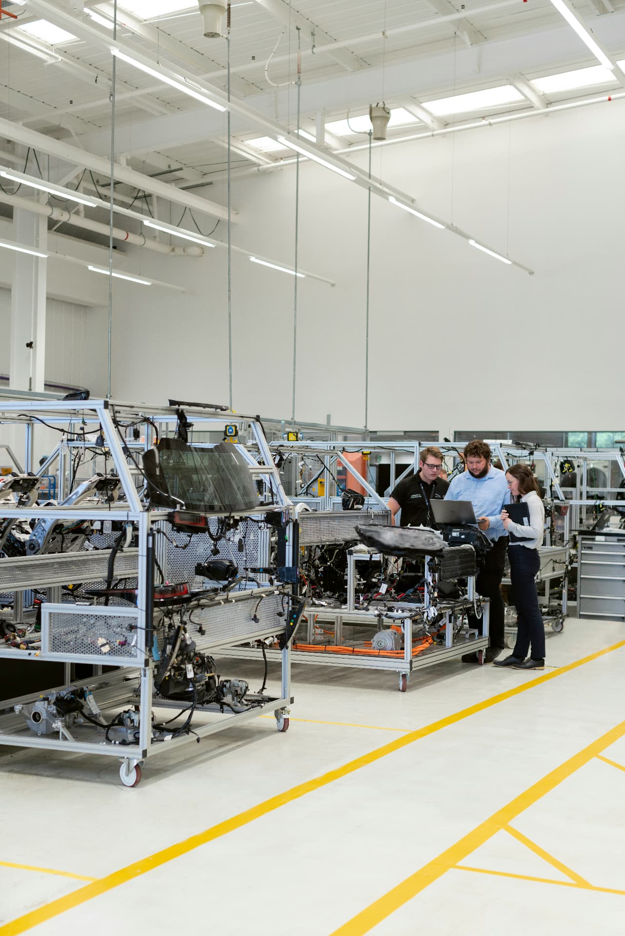 Engineers reviewing wiring harness test rigs in a laboratory